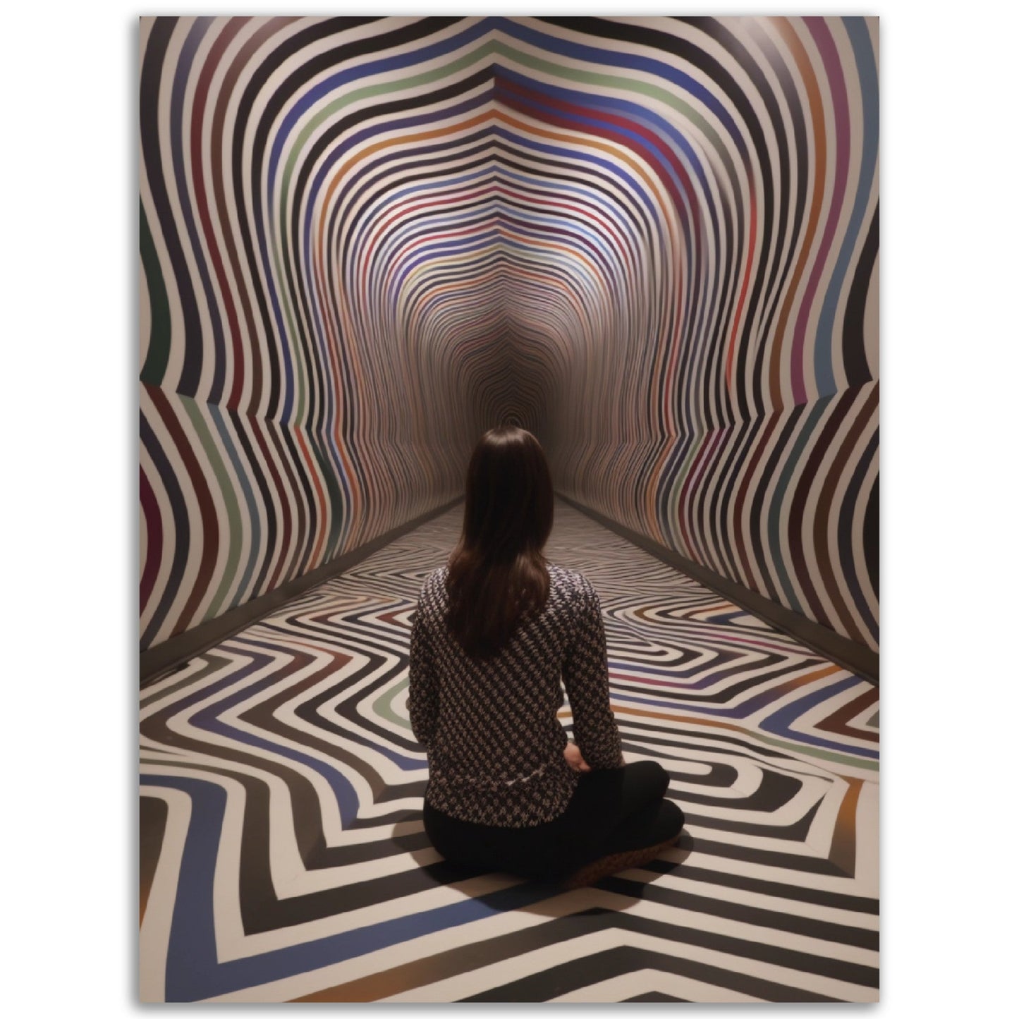 A woman sitting on the floor in front of The Hypnotic Labyrinth, surrounded by high quality posters and colored wall art.
